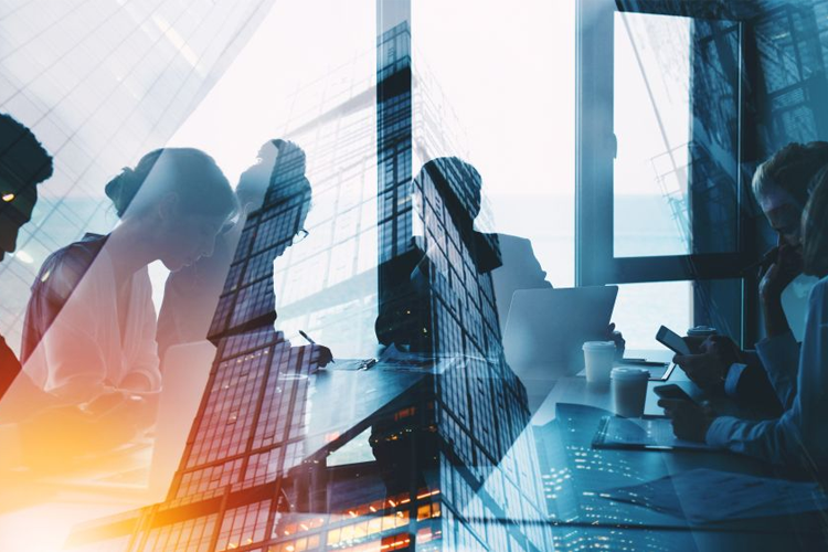 Silhouetten junger Fachkräfte in einem modernen Büro, überlagert von Wolkenkratzern einer Stadt.